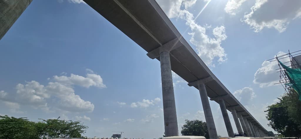 Elevated concrete viaduct under construction against a blue sky